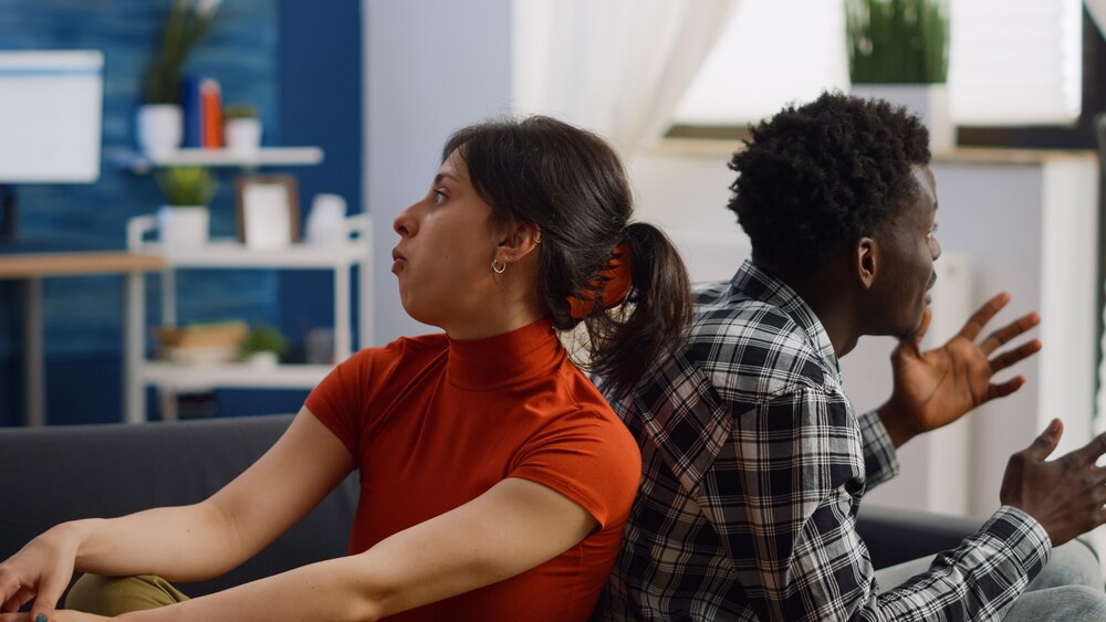irritated-interracial-couple-getting-into-argument-sofa_482257-23111.jpg