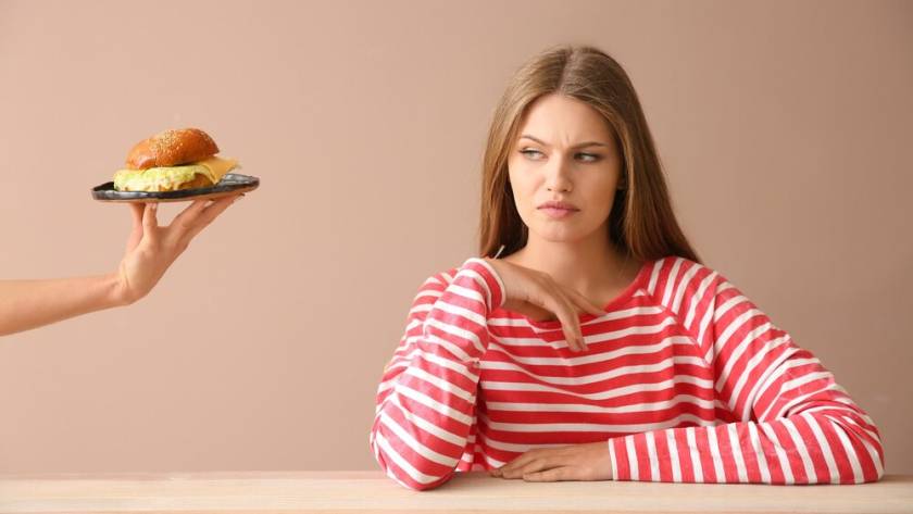 hand-suggesting-burger-displeased-young-woman-table_392895-19580.jpg