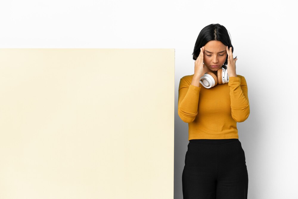 young-woman-listening-music-with-big-empty-placard-isolated-background-with-headache_1368-193678.jpg