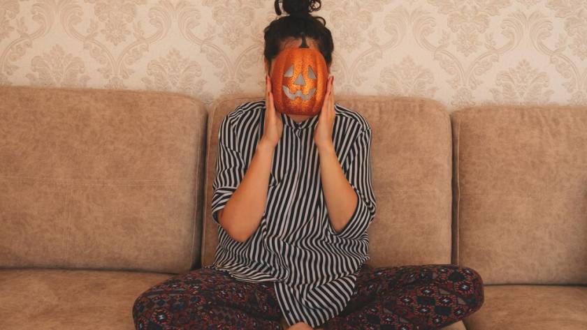 young-woman-striped-blouse-sits-sofa-holds-halloween-pumpkin-near-her-face_88775-1644.jpg