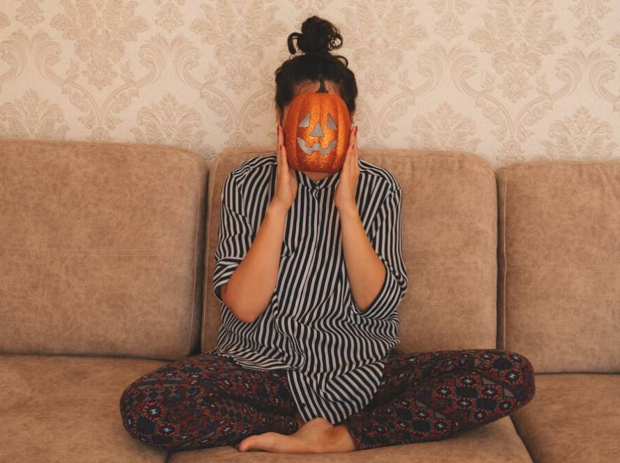 young-woman-striped-blouse-sits-sofa-holds-halloween-pumpkin-near-her-face_88775-1644.jpg